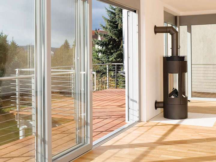Wohnzimmer mit bodentiefen Schiebefenstern zum Balkon